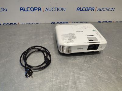 a white projector sitting on top of a table next to a cord