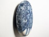 a blue and white stone on the wall next to a white wall