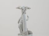 a white figurine of a woman holding a palm tree