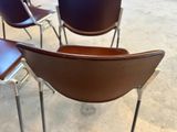 Plusieurs chaises sont alignées en rangée sur un sol en béton