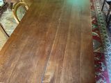 a long wooden table in a room with many chairs