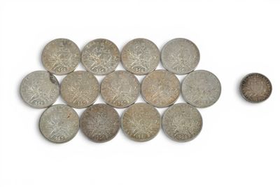 quelques vieilles pièces et une petite pièce posées sur une surface blanche