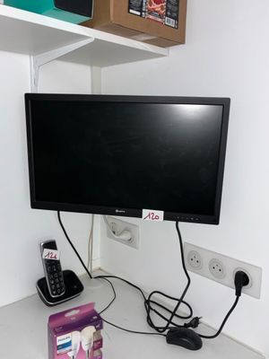 une télévision et un téléphone posés sur un bureau dans une pièce