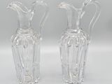 pair of clear glass vases sitting on top of a white surface