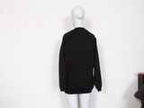 a mannequin wearing a black sweater and white pants