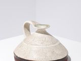 un vase blanc posé sur une table blanche