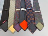 many ties that are lined up together on a table