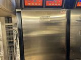 two stainless steel refrigerators in a kitchen with a window
