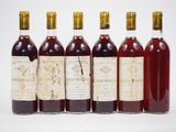 six bouteilles de vin sont alignées dans une rangée