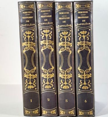 three books are lined up in a row on a white surface