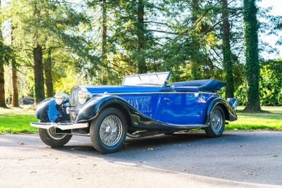 a blue vintage car parked on the side of the road