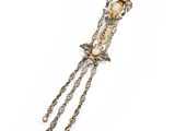 a close up of a gold and white broochle on a white background