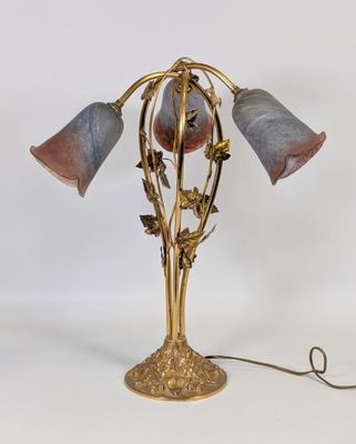 une photo d'une lampe de table sur laquelle sont posées trois fleurs