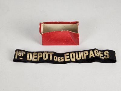une boîte rouge ornée d'un ruban noir et une boîte rouge sur laquelle est noué un ruban noir