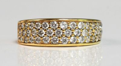 gros plan d'une bague en or et diamants sur une surface blanche