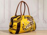 an image of a yellow handbag sitting on top of a wooden floor