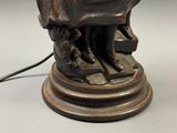 a bronze statue of a woman reading a book