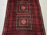 a red and black rug on a white floor