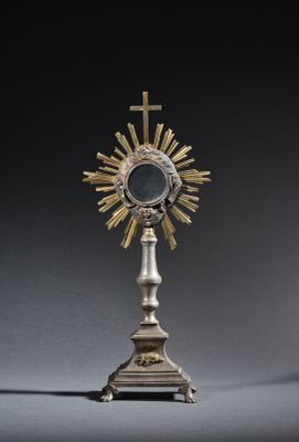 an image of a silver and gold cross on a pedestal