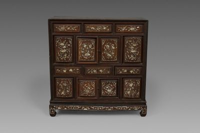 une commode ancienne en bois, avec des panneaux sculptés et des tiroirs