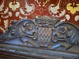a wooden bench with ornate carvings on it in front of a wallpaper