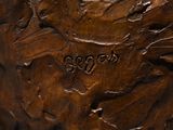 carved wood carving of a bird on a branch with leaves