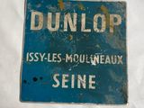 un panneau bleu sur lequel est inscrit « Dunlop »