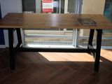 une table en bois sur laquelle est posé un livre, devant une fenêtre