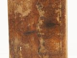 an old book with a torn cover sitting on top of a white surface