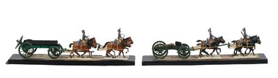 two figurines of horses pulling a carriage with a man on it
