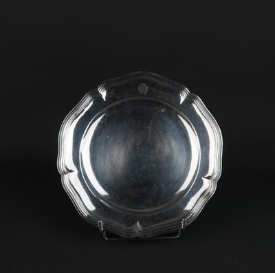 a silver plate on a stand against a black background