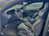 a car with its door open sitting on the side of the road