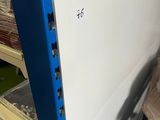a blue and white refrigerator in a store with plastic wrapped around it