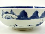 a blue and white bowl sitting on a white surface
