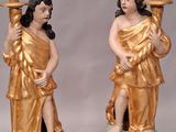 une paire de statues représentant un homme et une femme tenant une bougie