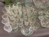 many glasses and vases sitting on a table