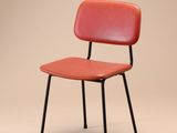une image représentant une chaise rouge à l'armature noire sur un fond beige