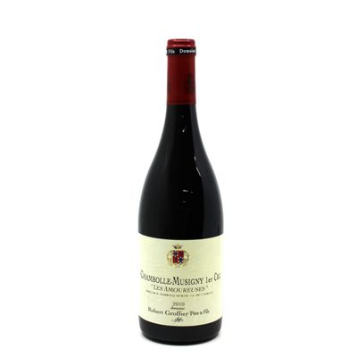 a bottle of red wine sitting on top of a white table