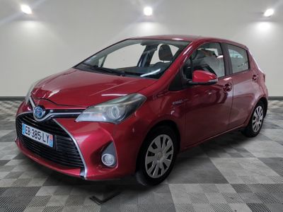 the red toyota yaris is parked on a checkered floor