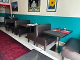 tables and chairs in a restaurant with a clock on the wall
