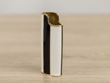 a black and white cigarette lighter sitting on top of a wooden table