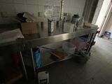 a large stainless steel table in the middle of a kitchen