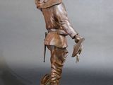 bronze statue of a man holding a bird on a wooden base