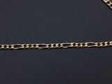 a close up of a gold chain on a black surface
