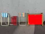 quatre chaises de couleurs différentes alignées le long d'un mur