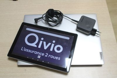 a tablet computer sitting on top of a table next to a charger