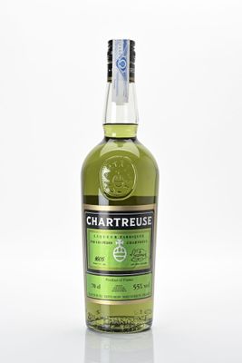 un gros plan d'une bouteille de Chartreuse posée sur une surface blanche