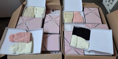 plusieurs boîtes contenant des bonnets et des mitaines tricotés, posées sur une table