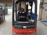 a red fork truck parked inside of a warehouse