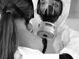 the woman is wearing a protective suit and holding a gas mask